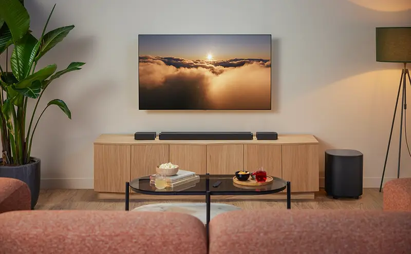 Wall-mounted TV with sound bar and subwoofer in a living room